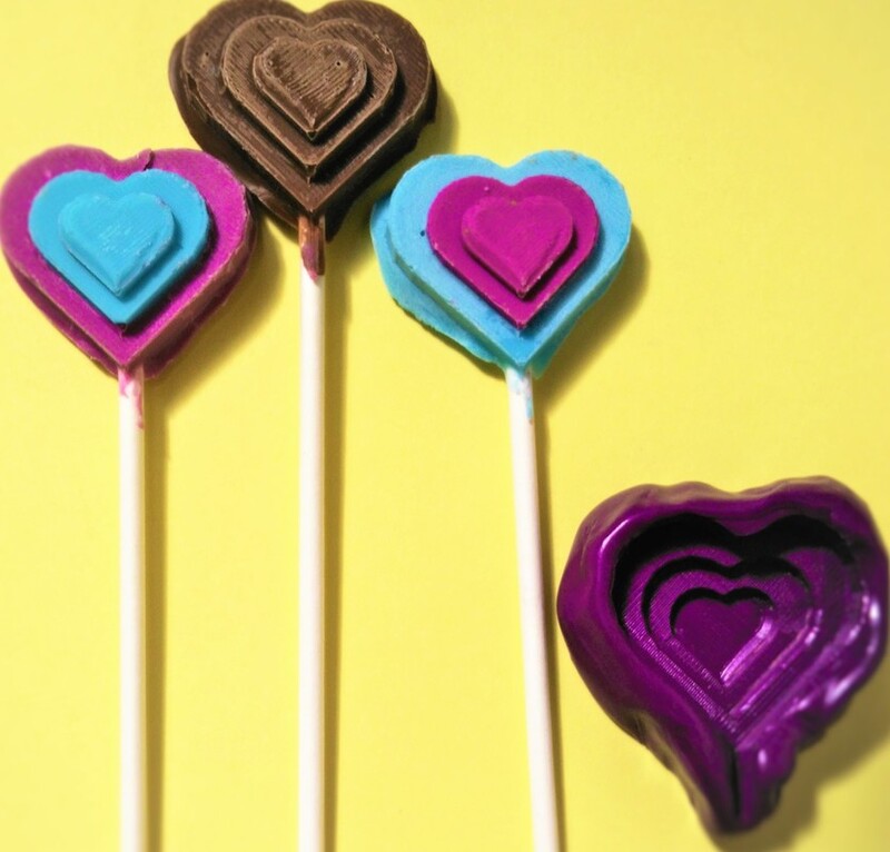 the mold, cast, and replicas of a heart-shaped chocolate lollipop