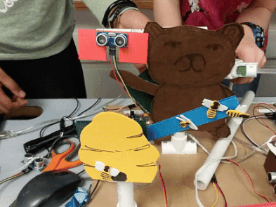gif of working arduino project, bees flying over a hive and a bear waving a paw
