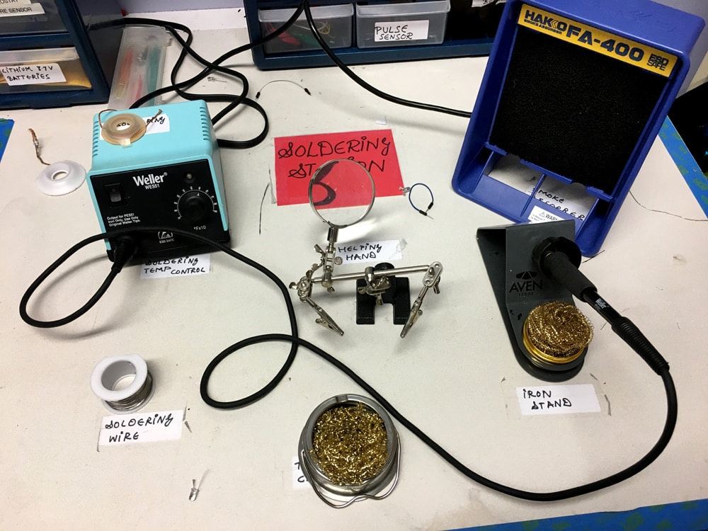 soldering station set up with each item labeled: wire, iron stand, helping hand, and temp control
