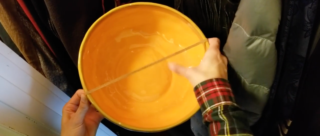 photo of a bowl with rubber band stretched across it to play as an instrument