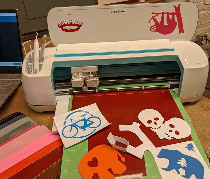 photo of a cricut vinyl cutter machine with several cut vinyl projects