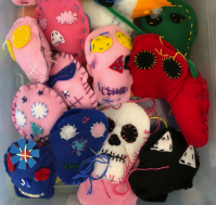 hand-sewn plush skulls in a variety of colors