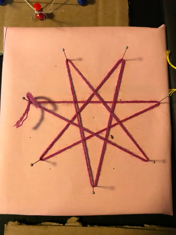 a seven pointed star created with string and pins