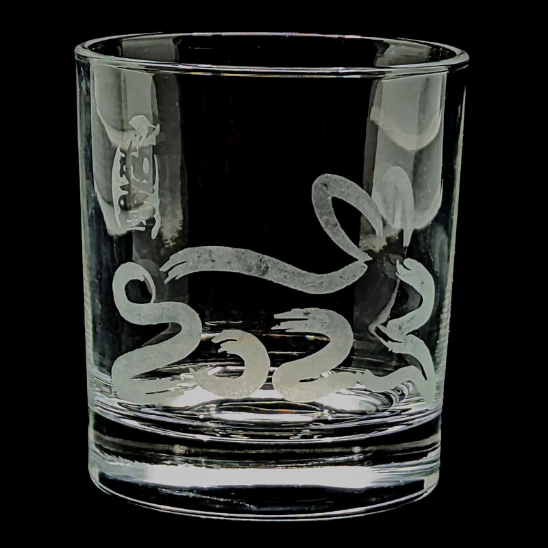 short tumbler glass with etched design depicting "2023" in the shape of a rabbit