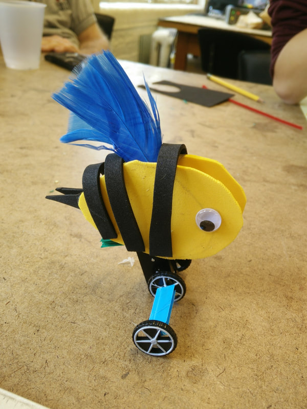a custom-built wind-up toy topped with a bee-like, googly-eyed creature