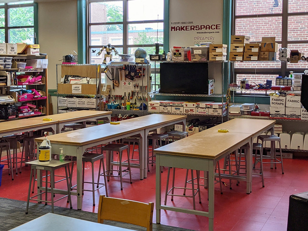 Photo of a maker space with tools hanging neatly on the wall and a big work table